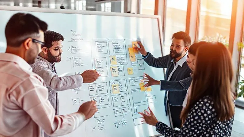 A photorealistic, professional photography, 8K, cinematic lighting, sharp focus, depth of field, shot on a high-end DSLR of a diverse team collaborating around a large interactive digital whiteboard displaying a UX prototype. Multiple hands are gesturing, adding digital sticky notes, and drawing annotations, reflecting a seamless and efficient digital feedback process using advanced collaboration tools in a modern, brightly lit tech office. The scene should evoke efficiency and digital synergy.